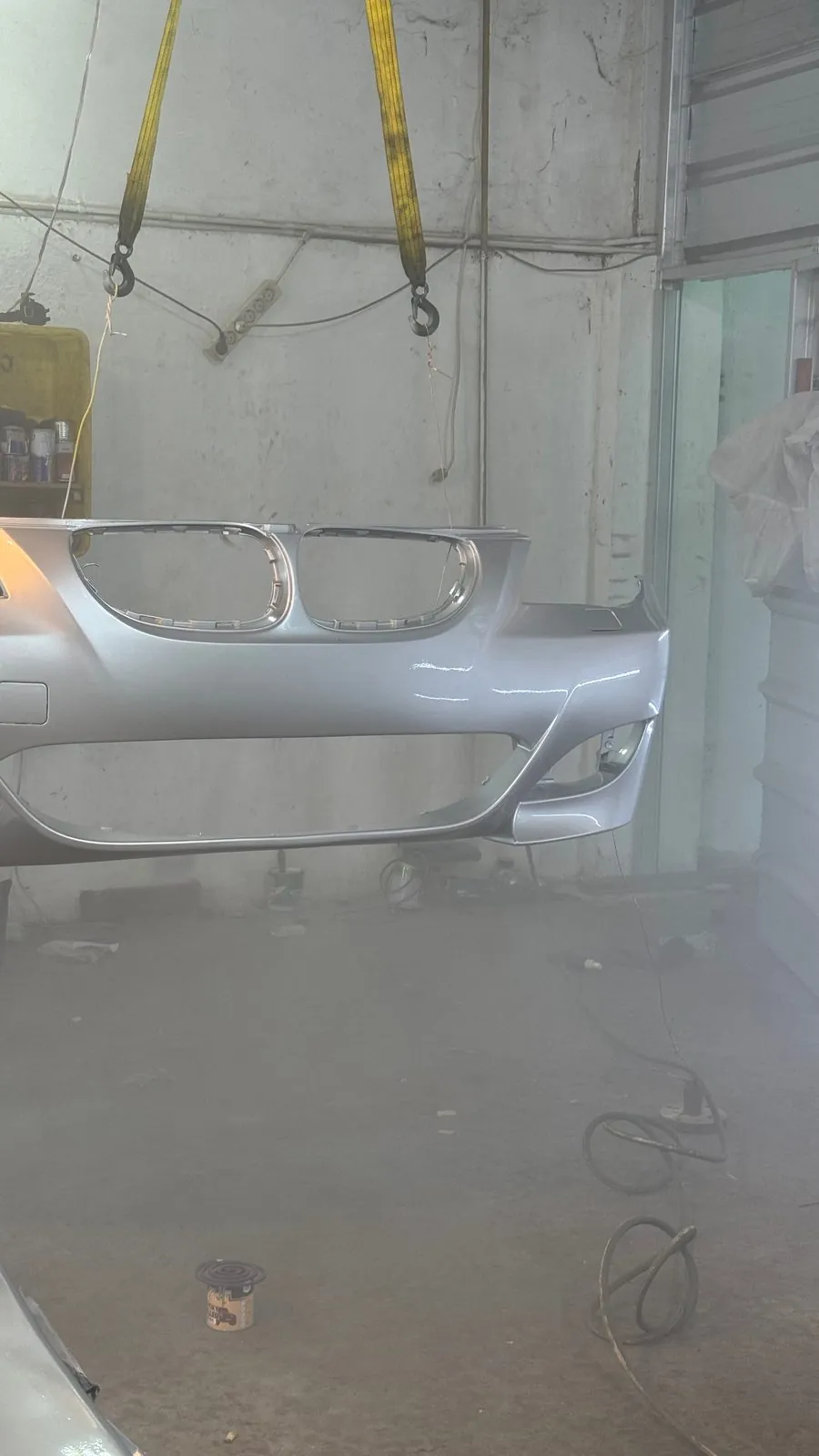 Silver BMW 5 Series front bumper with the kidney grille in the spray booth