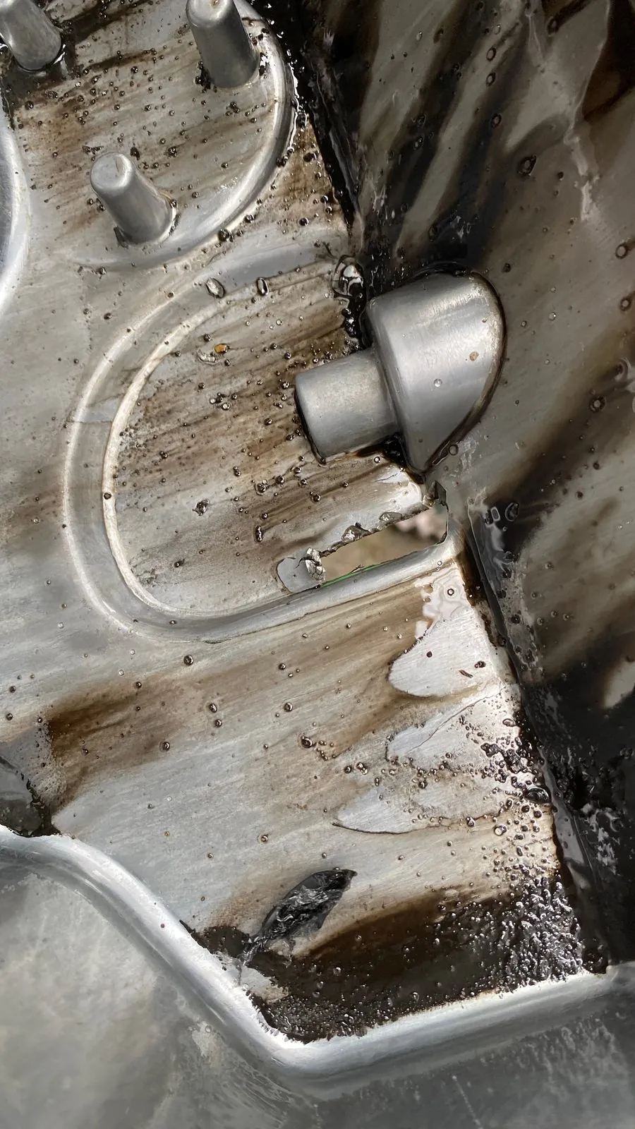 Inside of a cracked engine sump with a stud and weld, E30