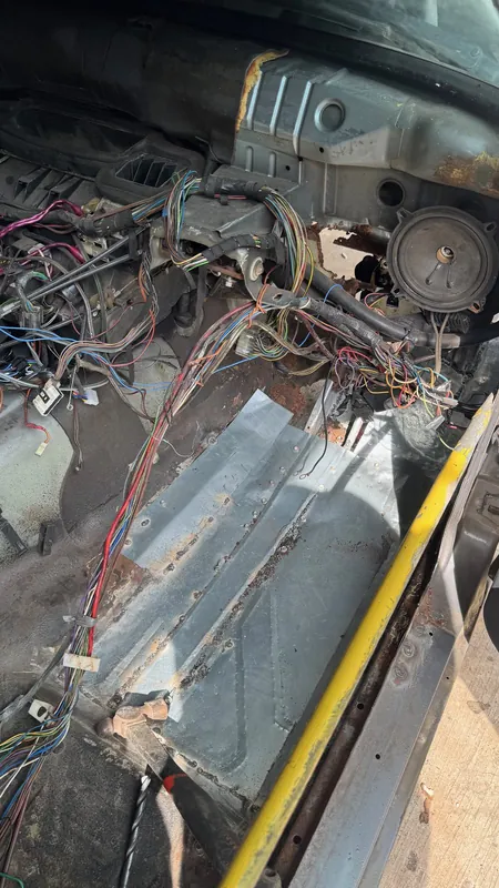 Stripped E30 cabin with the wiring loom and a new patch in the floor