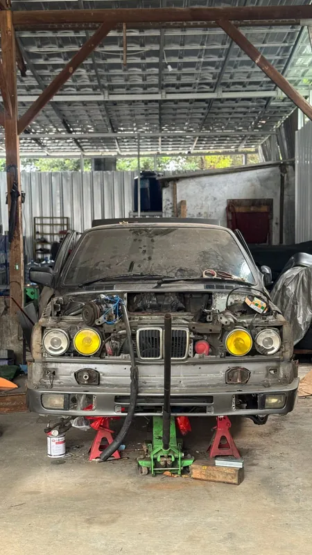 E30 front on jack stands in the shed, engine out