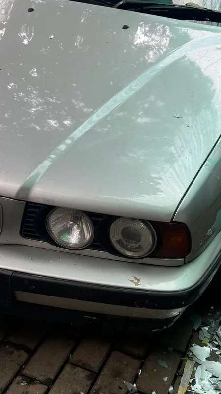 Front wing, bonnet and quad headlight of the silver BMW E34