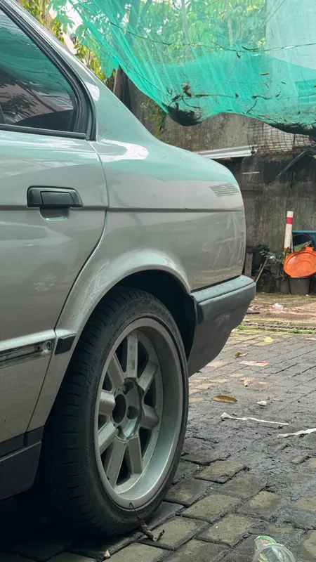 Side of the silver E34 with its alloy wheel