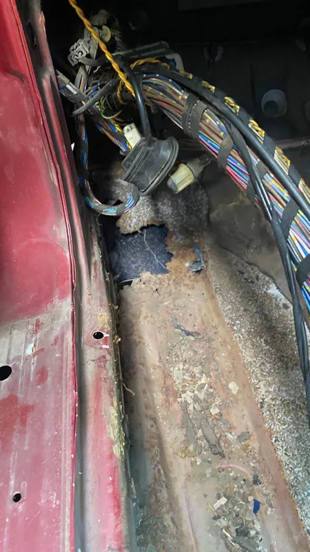 Rusted sill and door-aperture seam with the wiring loom exposed