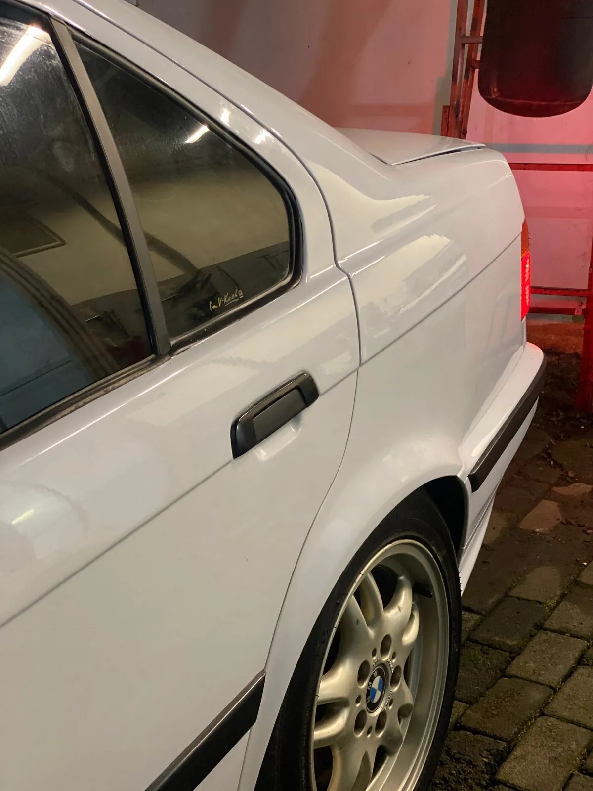 Rear door and quarter of the white E36 with fresh paint and a black side moulding