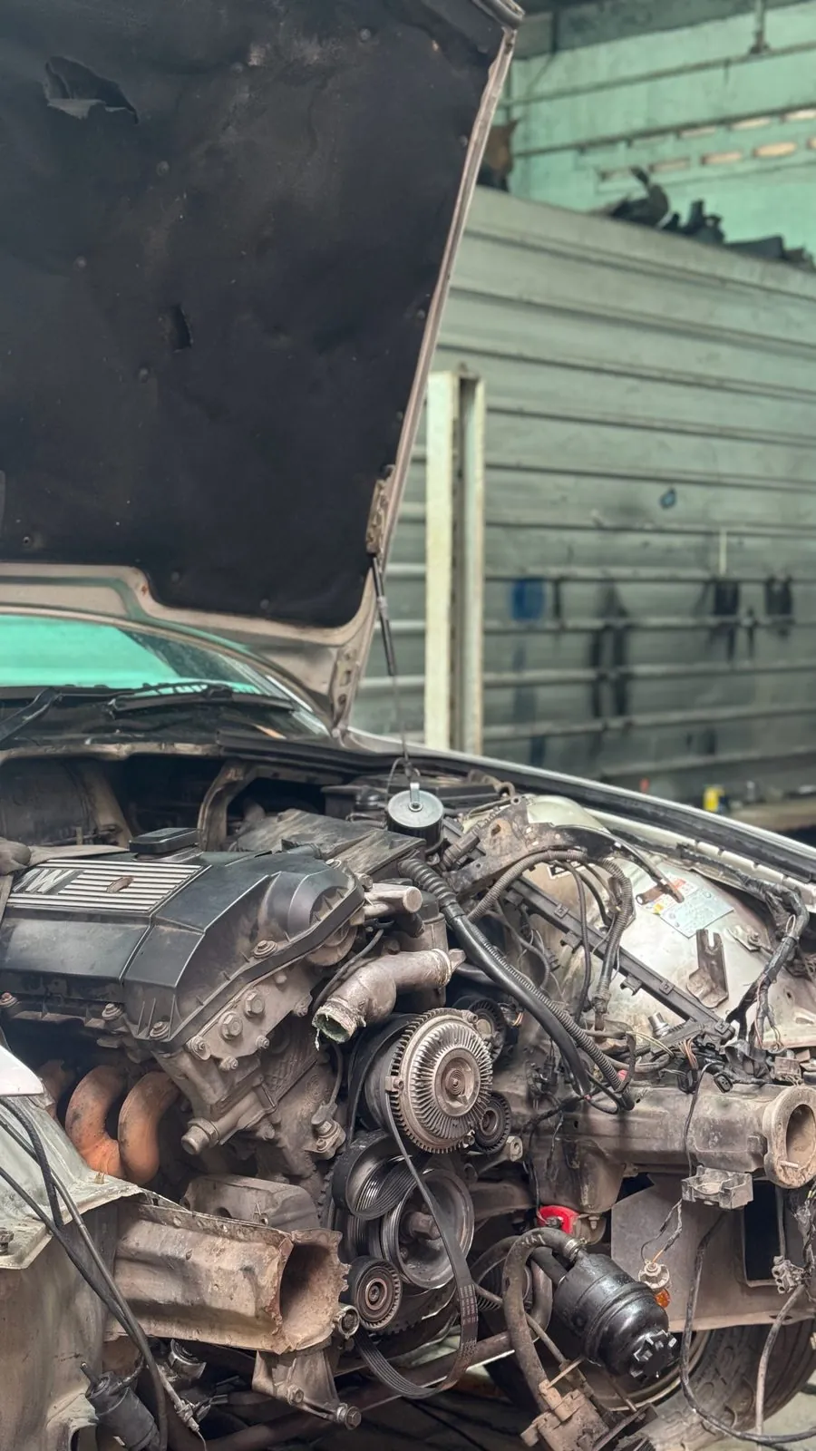 Silver E36 with the bonnet up, engine bay partly stripped, engine still in
