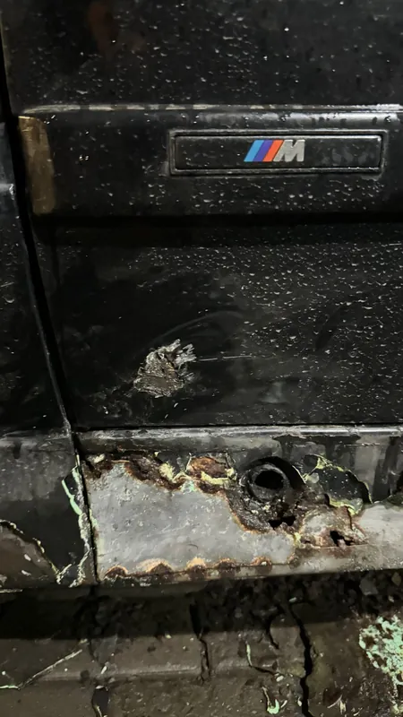 Pitted, corroded lower edge of the E36 side skirt by the M badge