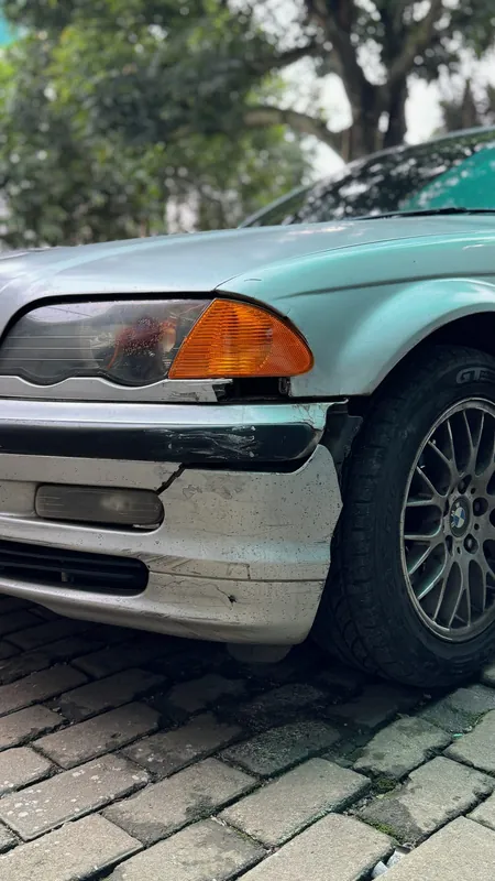 Cracked front bumper corner and headlight of the silver E46