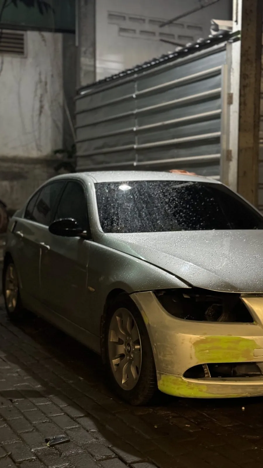 Silver E90 side view with front bumper in primer and headlight removed