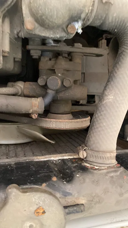 Carburettor linkage and radiator hose in the dusty engine bay