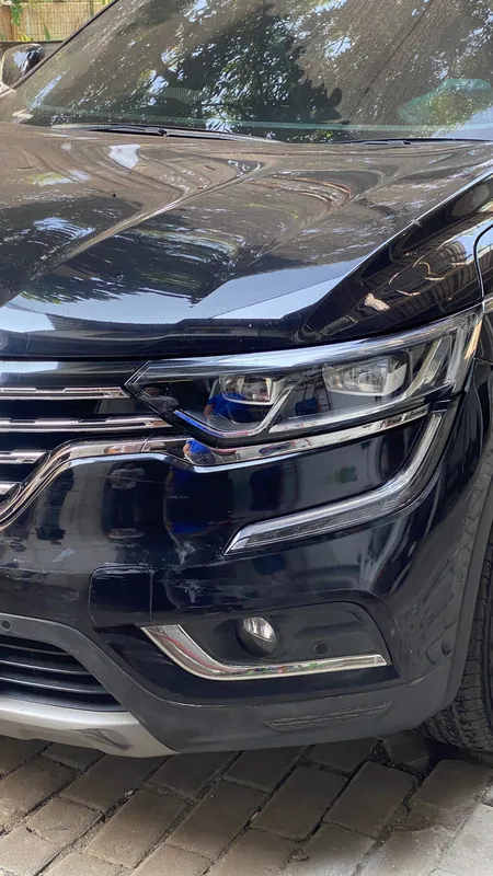 Dark blue SUV front end with a cracked front bumper corner