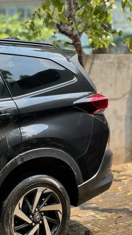 Dented and scratched rear quarter and arch trim beside the tail light