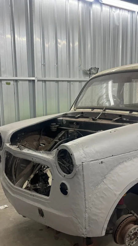 Front of the Fiat 1100 in primer with the bonnet open
