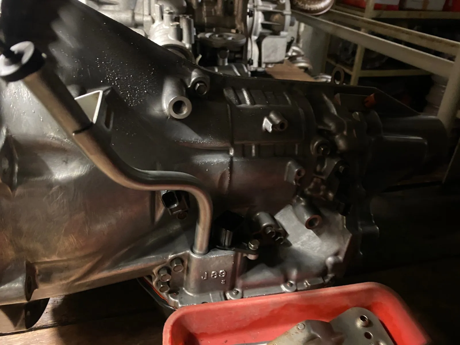 Gearbox casing and linkage on a stand with a red tray beneath