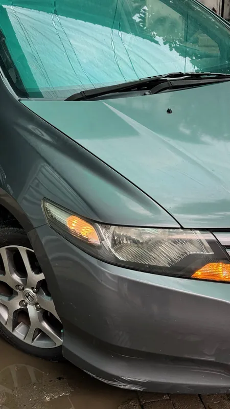 Front wing, headlight and alloy wheel of the grey Honda City