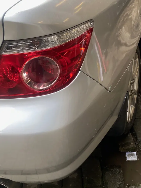 Rear lamp and creased bumper corner of the silver Honda City