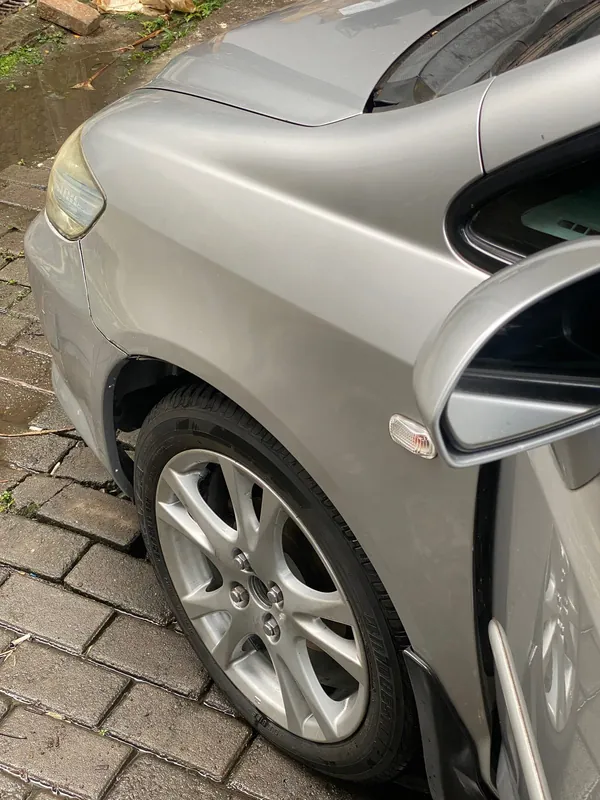 Front wing, wheel and folded mirror of the silver Honda City