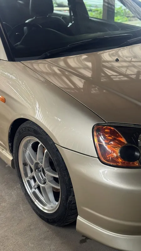Front wing and wheel of the gold Civic