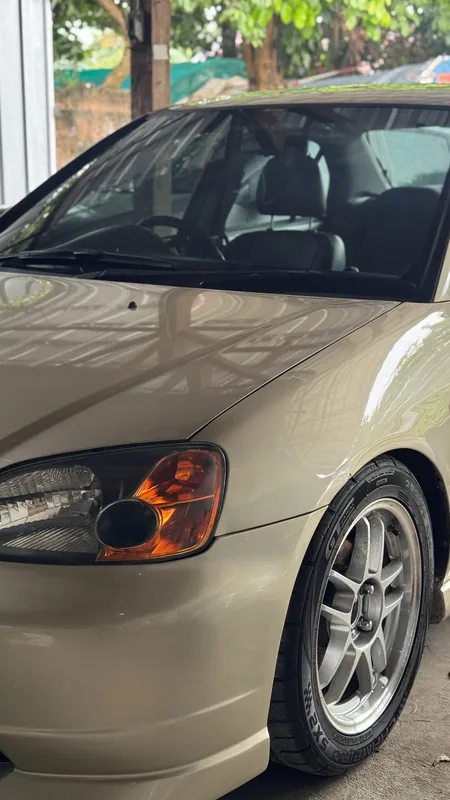 Front wing, headlight and wheel of the gold Civic