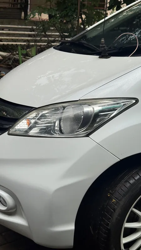 Front wing and headlight of the white Honda Freed