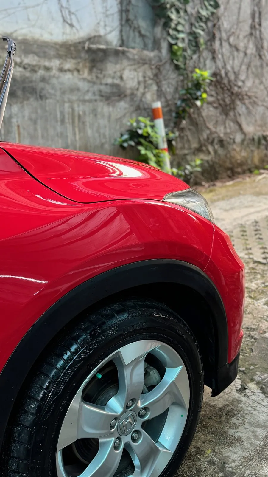 Front wing, black arch trim and alloy wheel of red HR-V