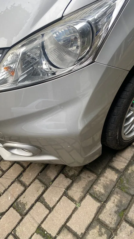 Front wing crease and headlight of the silver MPV