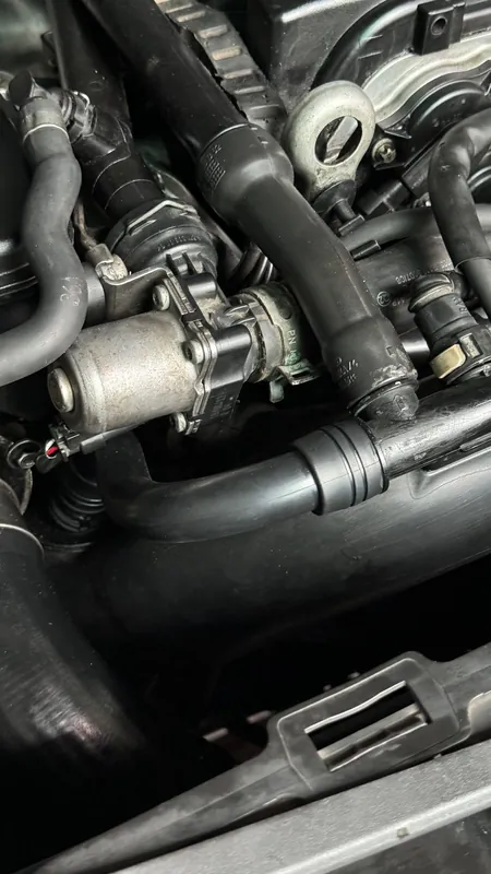 Hoses and a valve on the side of a Mercedes four-cylinder engine