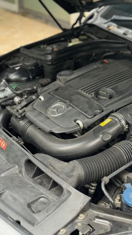 Four-cylinder petrol engine bay of the Mercedes with its engine cover