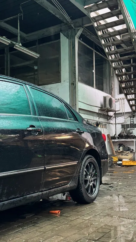 Black Toyota Corolla Altis side in the workshop yard