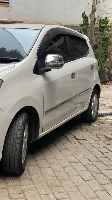 White Toyota Agya side and front quarter in the yard