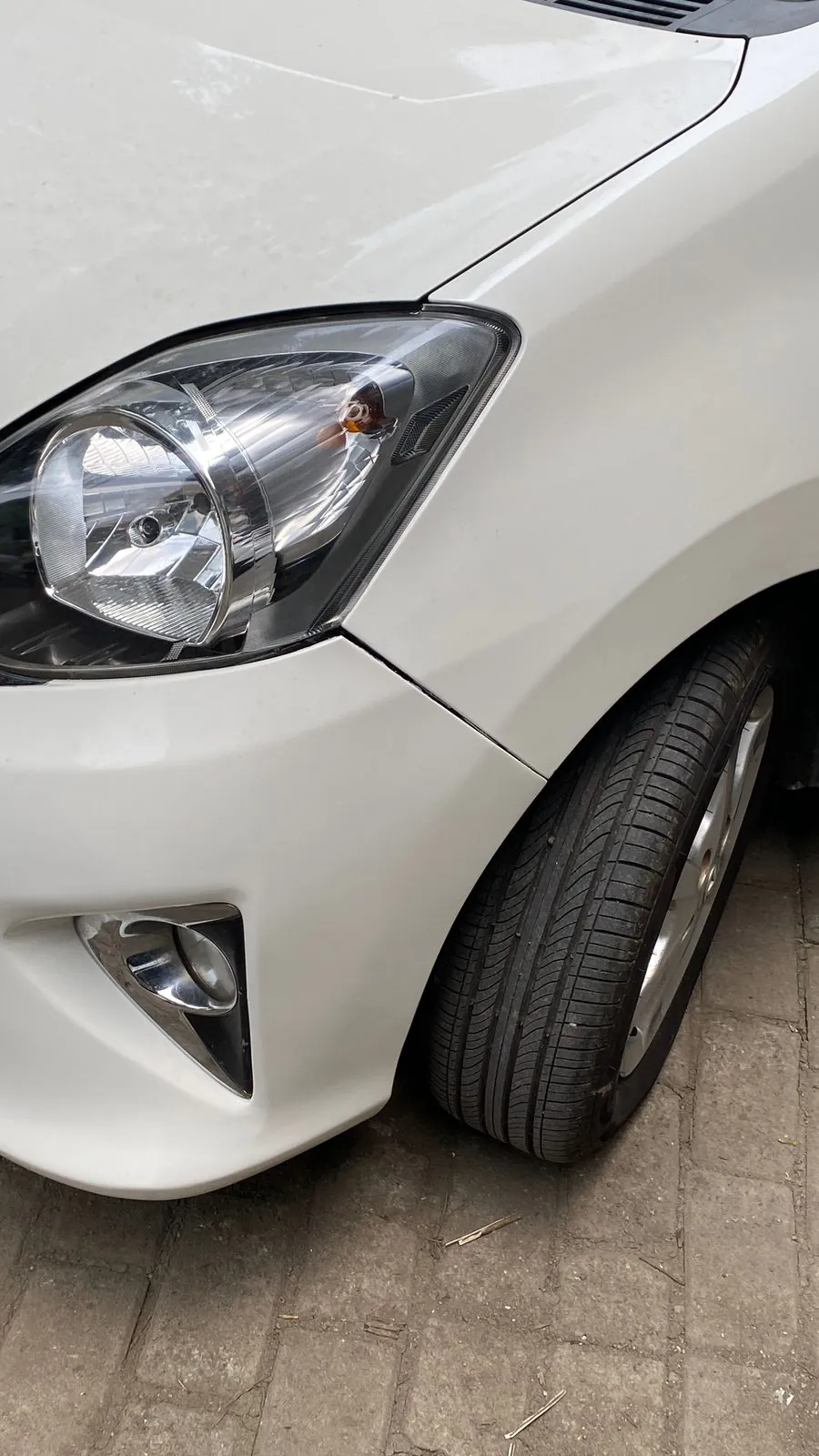 Front wing, headlight and fog lamp of the white Agya
