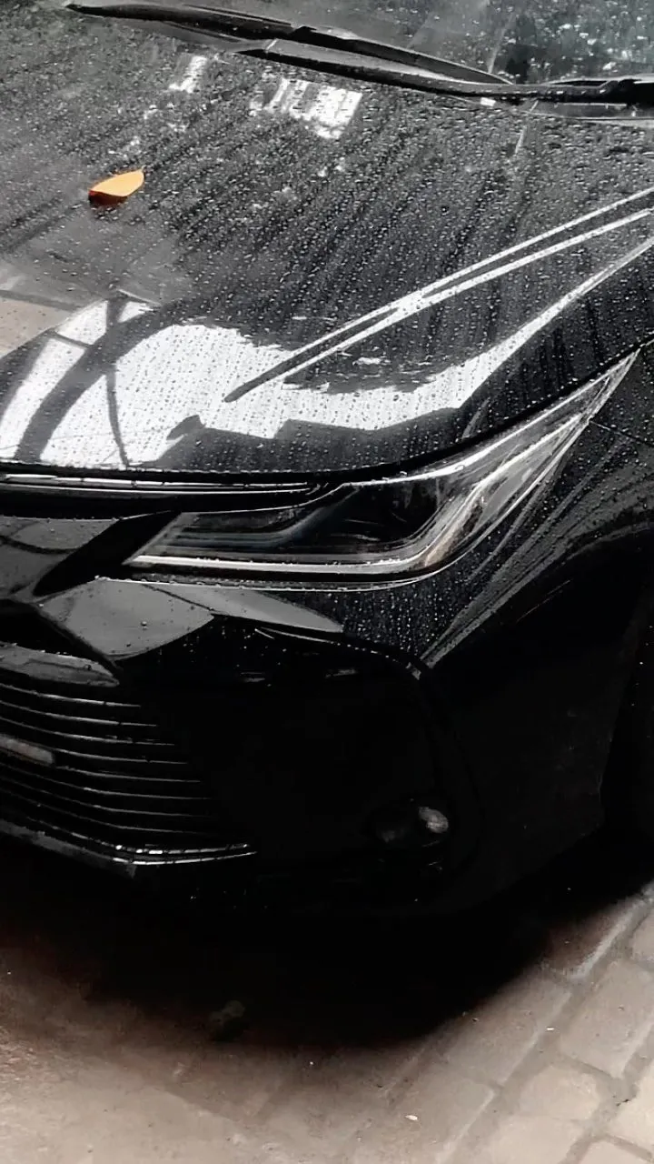 Wet front corner of the black Corolla Altis at the start of the job