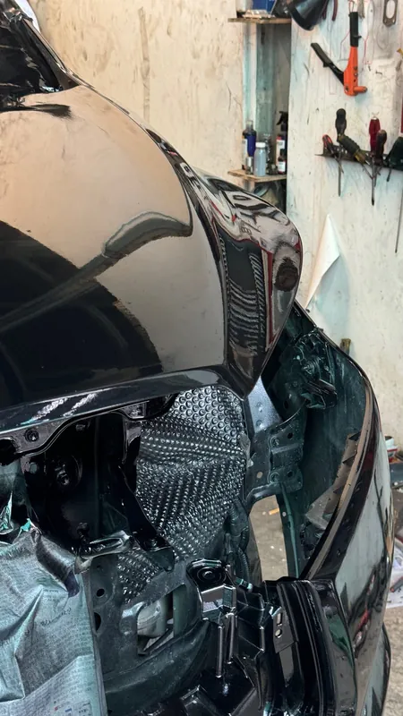 Front corner of the black MPV with the bumper off