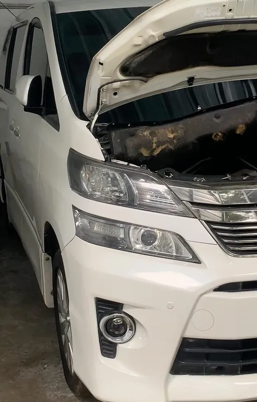 White Toyota Vellfire with the bonnet open in the workshop