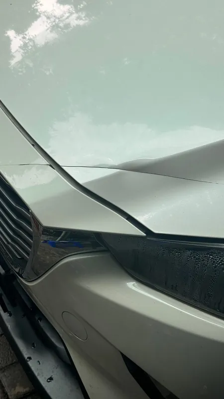 Crease across the bonnet of the white SUV